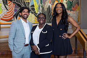 Two forensics fellows stand with their program director.