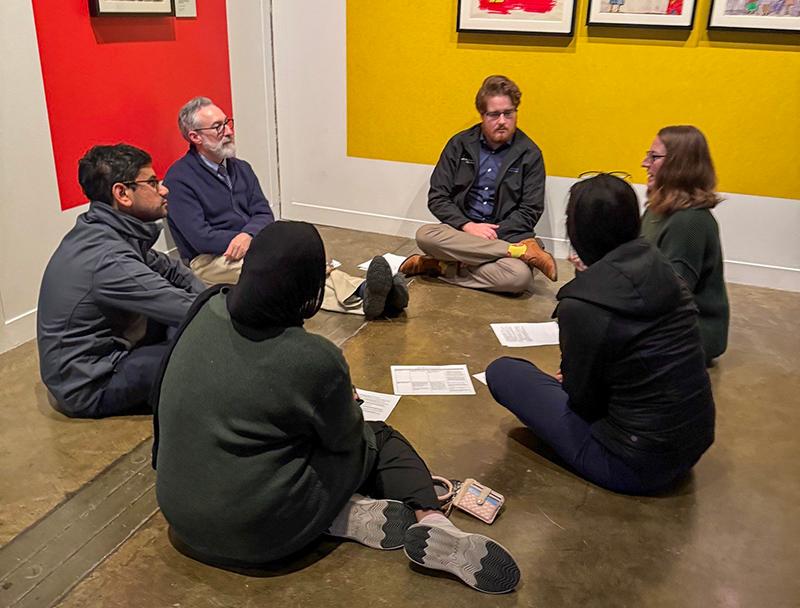 A group of learners discuss psychiatry while siting in a circle