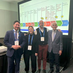 four people in front of presentation screen