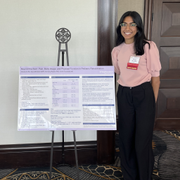 Mashal Ali standing next to her poster presentation