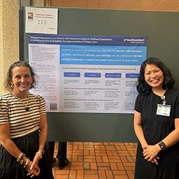 Dr. Veronica Edgar Bordes and Dr. Joan Chen stand in front of Chen's poster