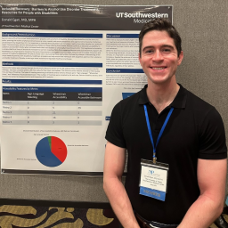 Dr Donald Egan poses in front of his research poster