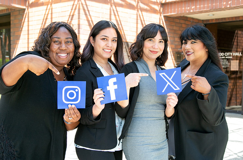 Lakewood city staff holding social media icon signs