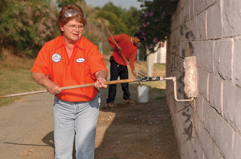 Diane painting a wall as part of volunteer day