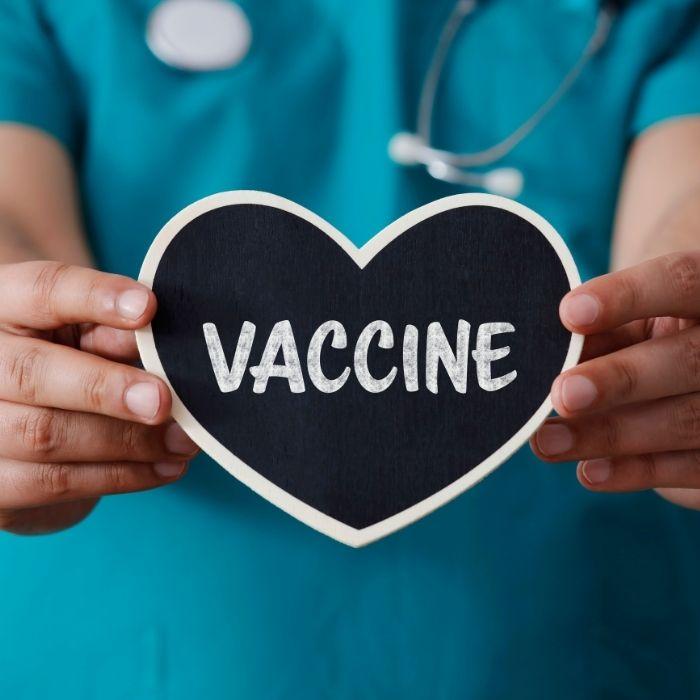 Image of health care worker holding a heart that says vaccine