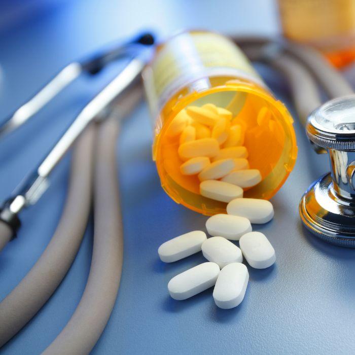 Photo of pills next to a prescription bottle with a stethoscope 