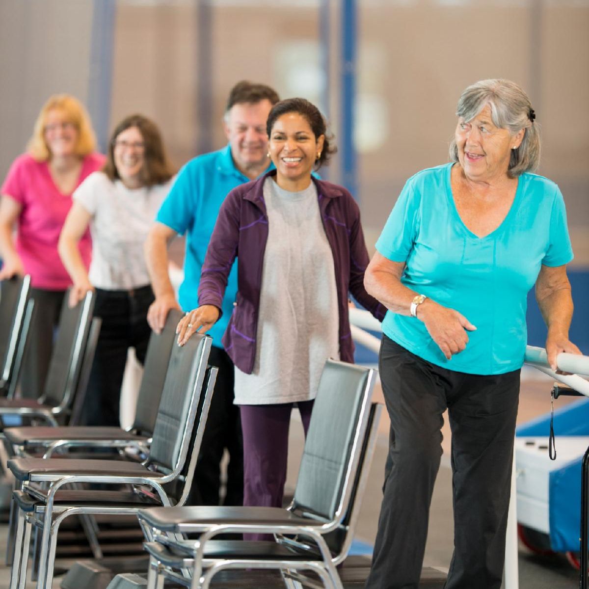 diverse people exercising with chairs