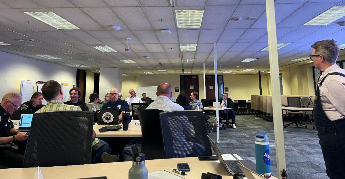 Many people sit in the MCEM EOC during an exercise.