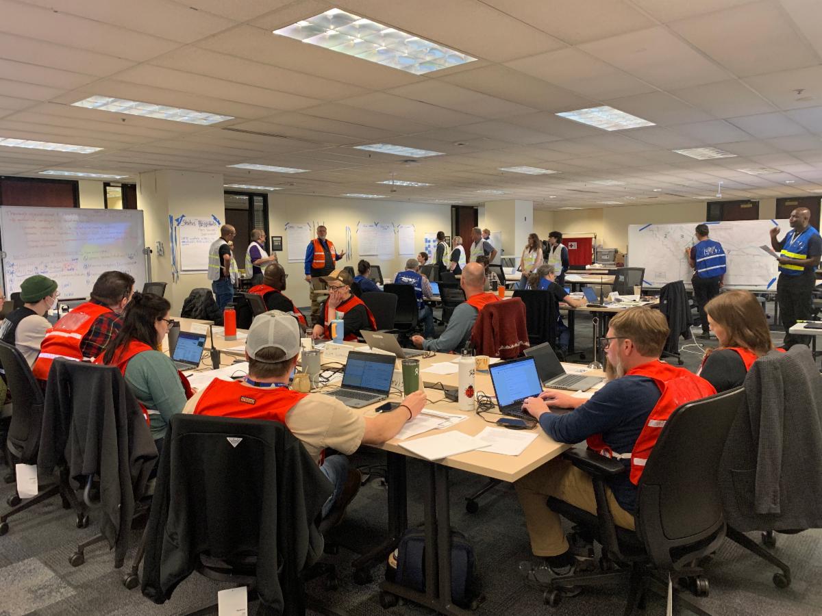 IronOR exercise participants sit and stand around tables.