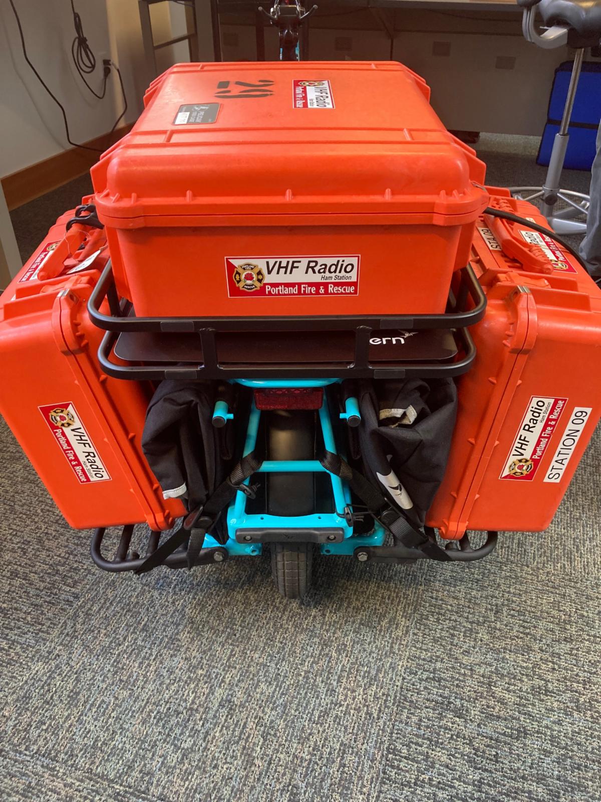 A bicycle with three VHF radio kits attached to the back rack