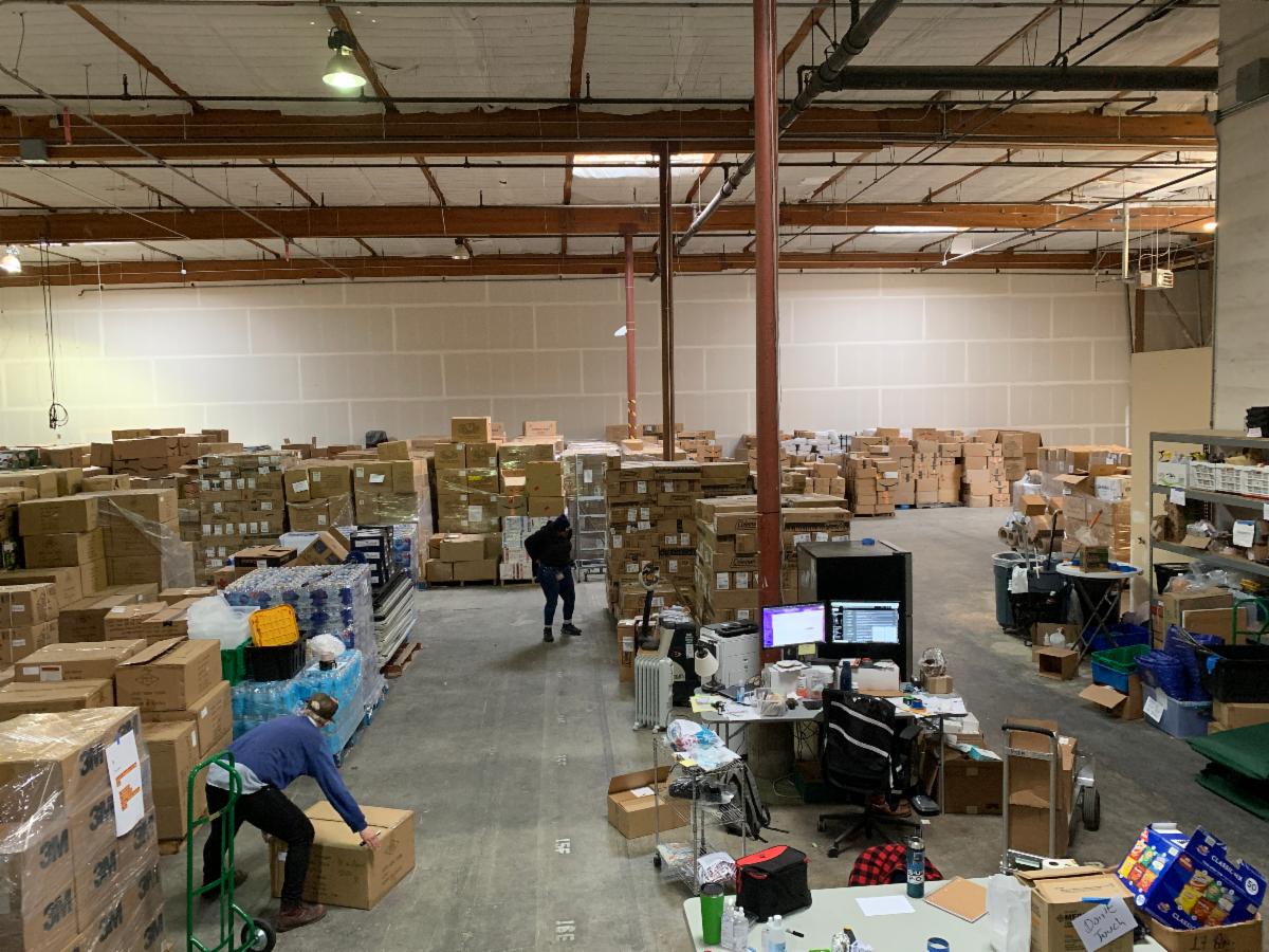 A view of a warehouse with multiple people moving items.