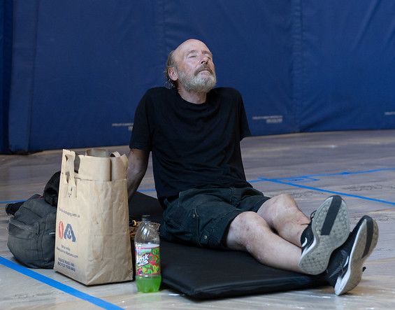 A man sitting on a mat in a cooling center