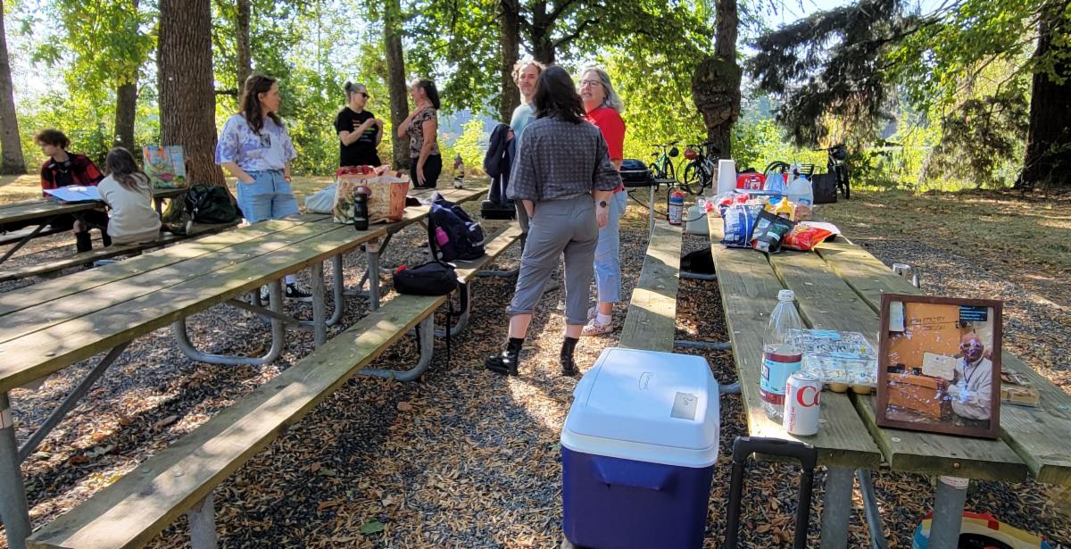 People gather over picnic tables sharing food with one another in memory of Jeff Washington.