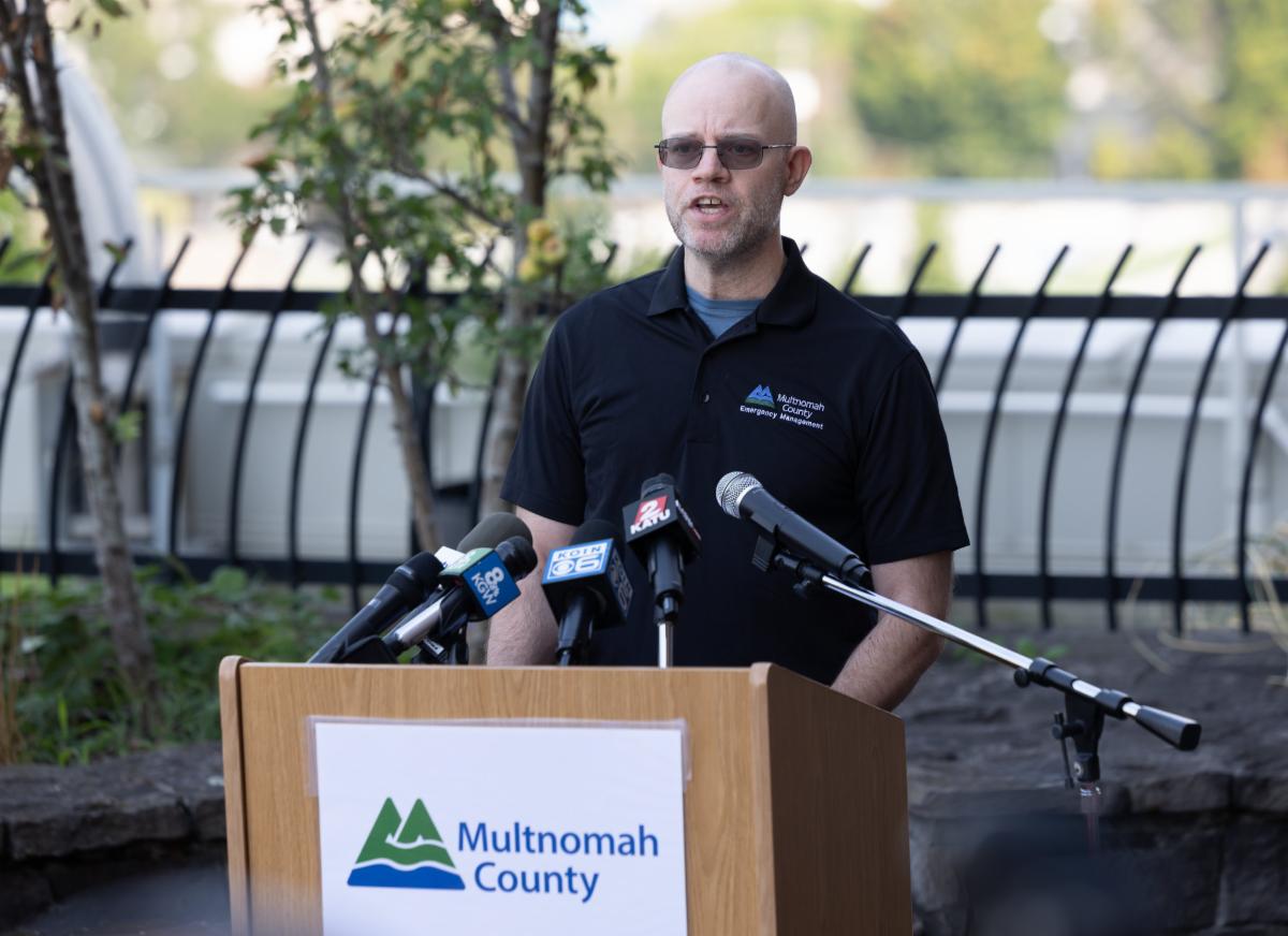 MCEM Director Chris Voss stands behind a podium at a press conference giving updates on the heat event.