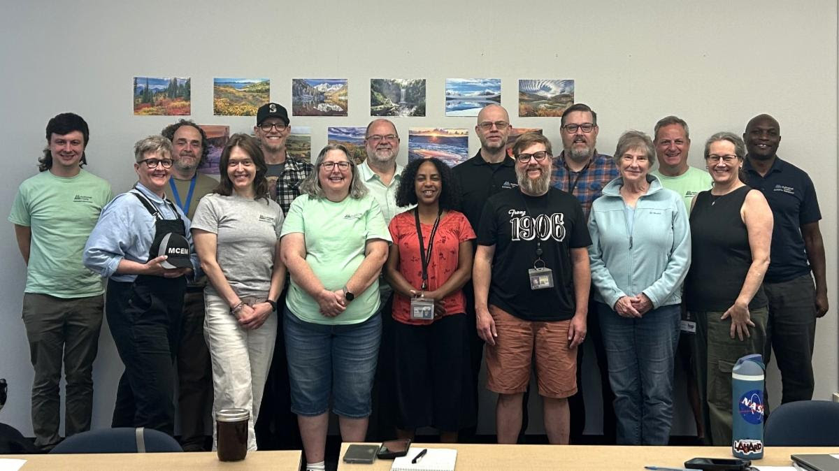 MCEM's staff stand together, smiling.