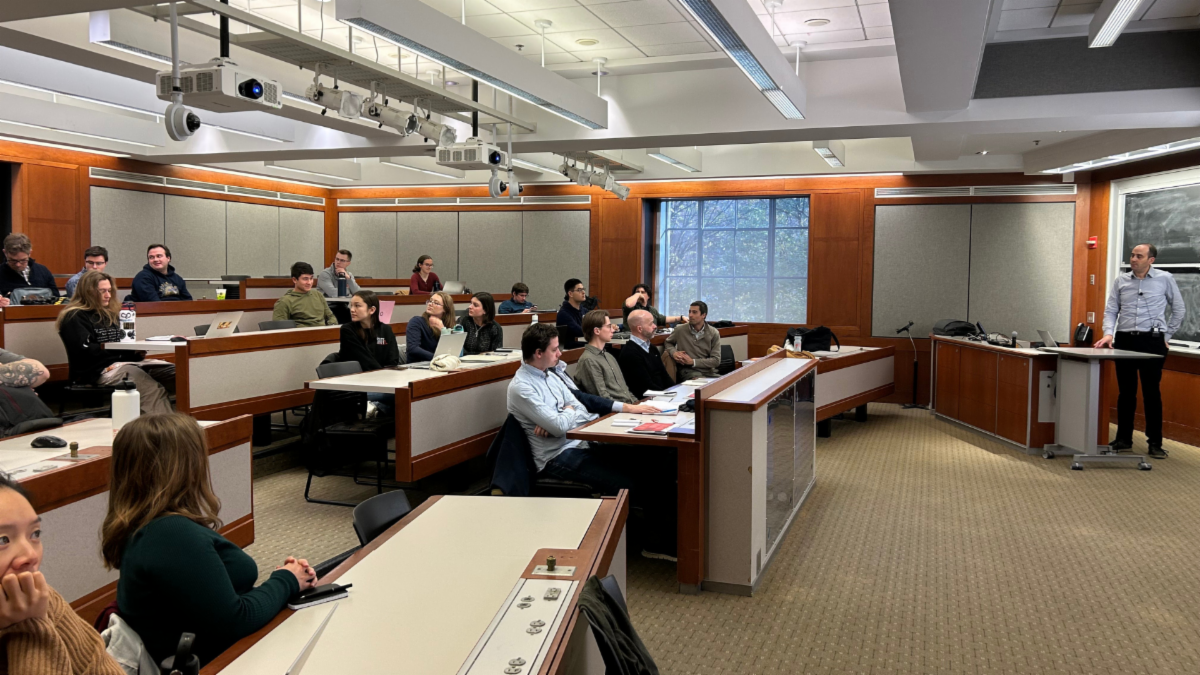 A speaker addresses an audience in a tiered classroom.