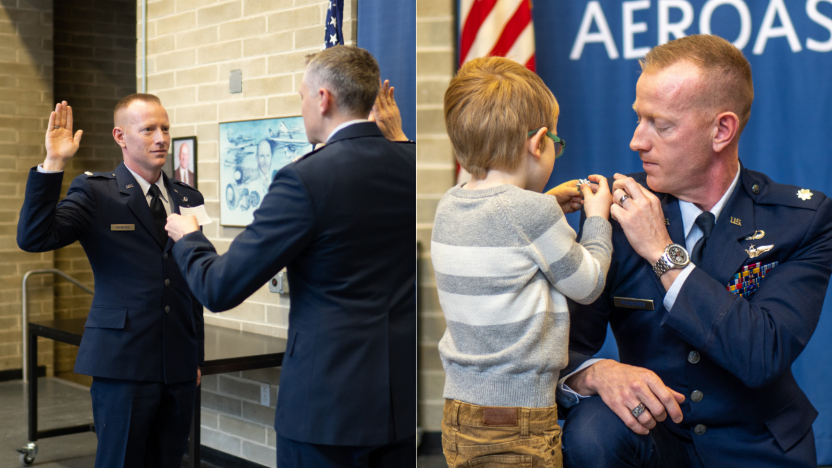 A military officer in uniform participates in a ceremony and kneels as a child pins a badge on him.