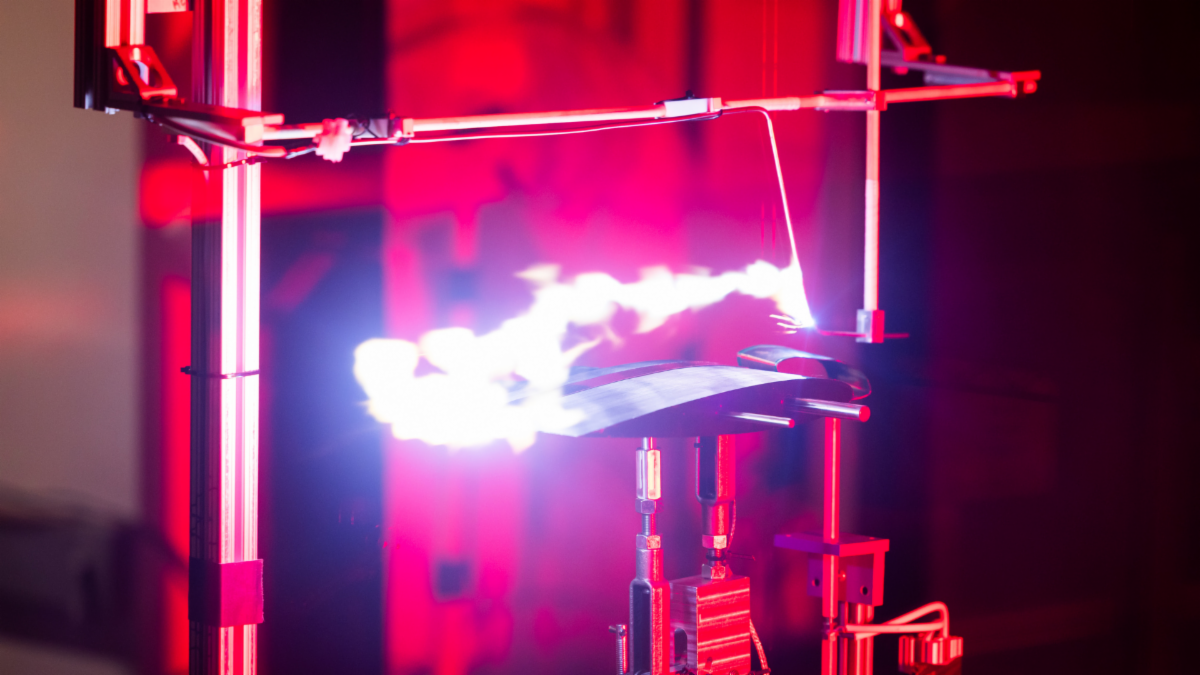 A lightning strike simulated over a small model of an airplane wing