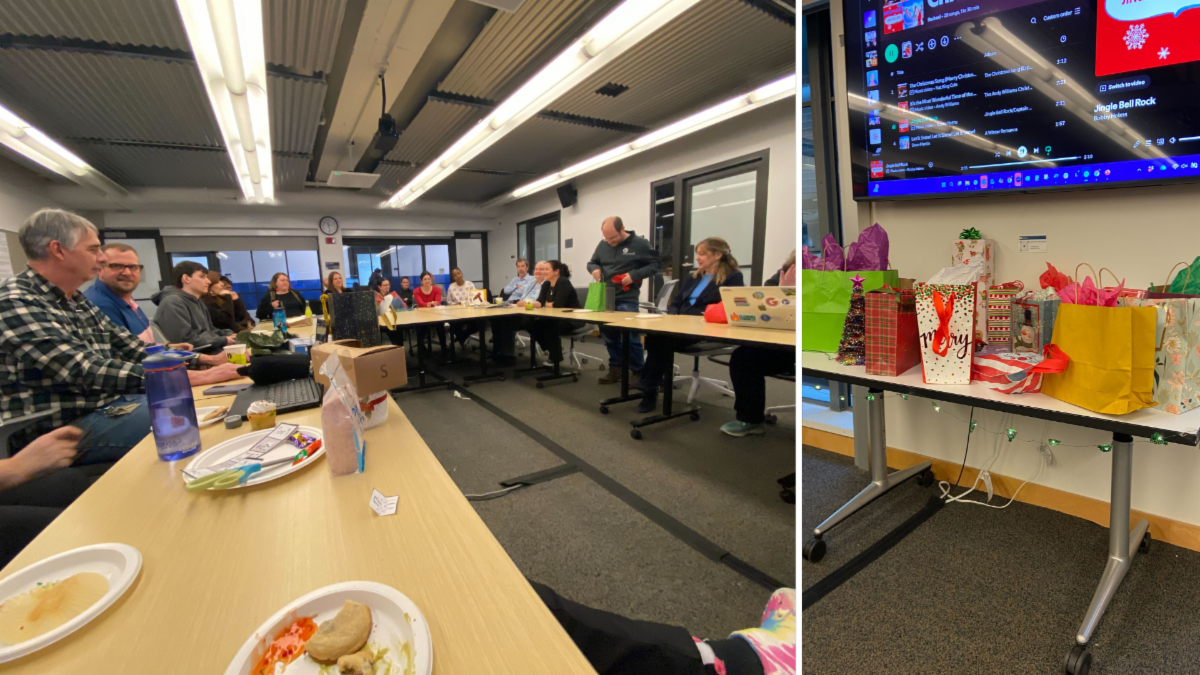 A conference room with people seated around a table, and a side table filled with colorful gift bags.