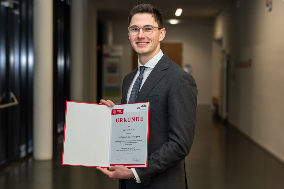 Leon in a suit, displaying his award