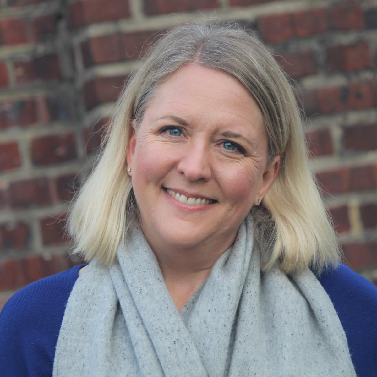 Headshot of Mara Gorman in front of a brick wall