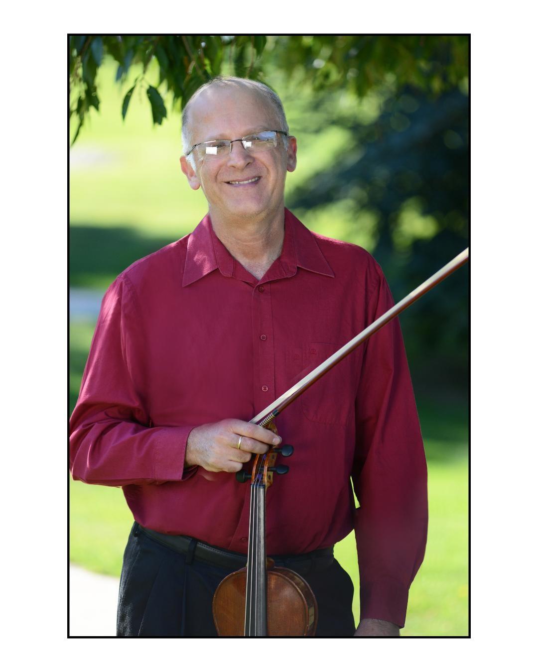 three quarter length portrait of Eliezer Gutman holding his violin outside