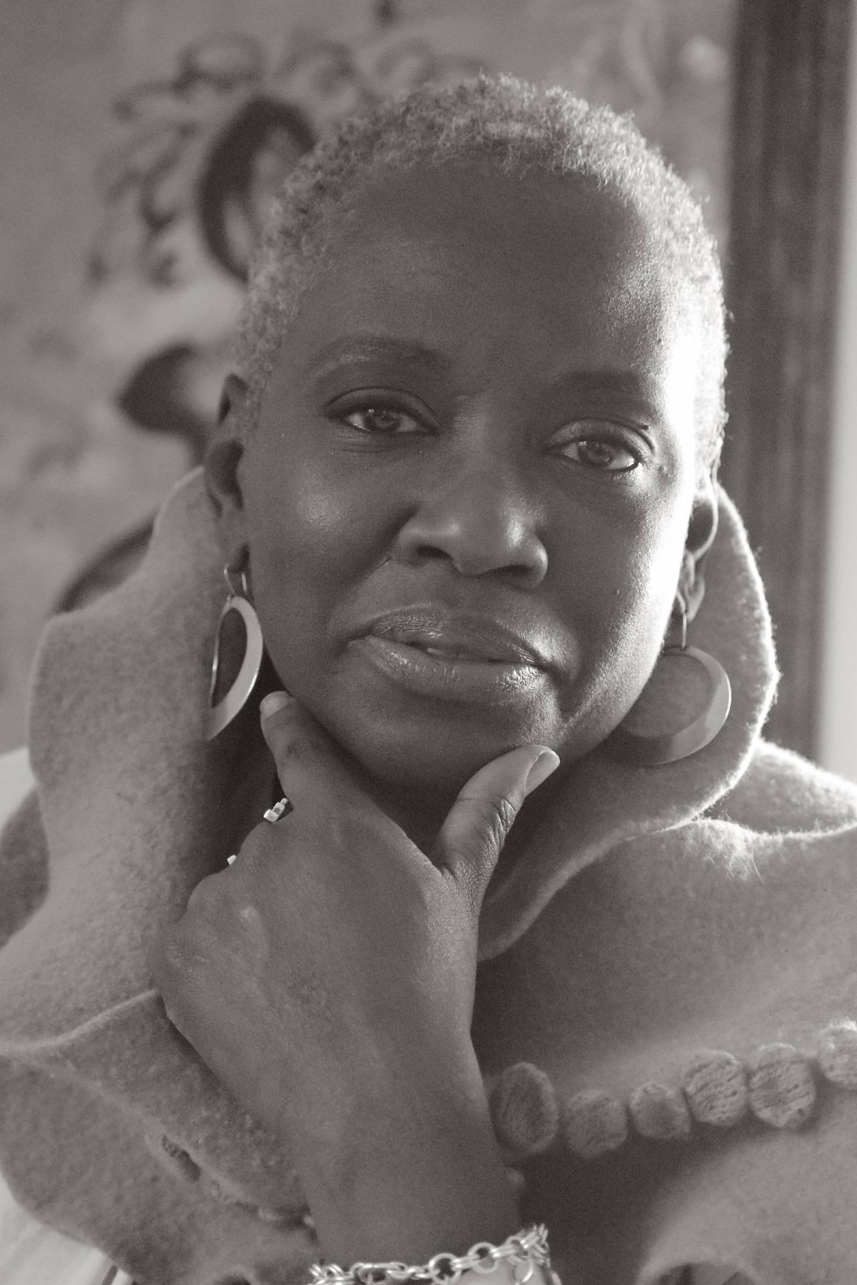 Headshot of Njideka Wiggins looking straight at the camera with her chin resting in her hand