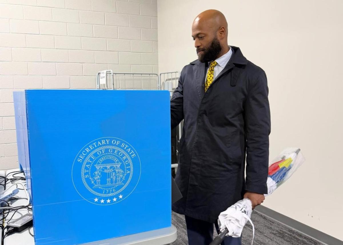 Commissioner Carden at the elections building looking at a voting booth