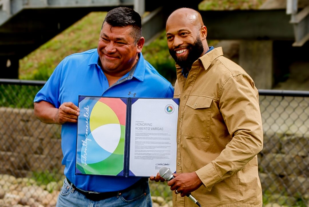 Commissioner Carden and Robert Vargas holding the resolution presented