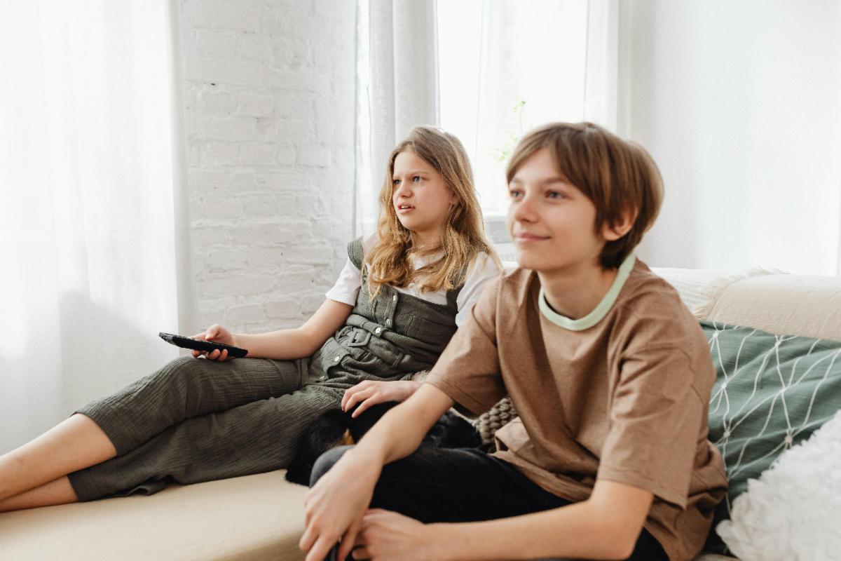 teen brother and sister watching TV