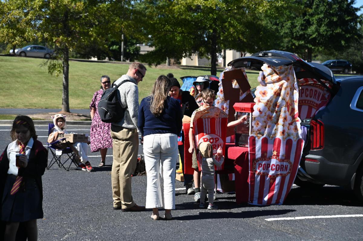 Visitors to Our Savior in Martinez get candy from a car trunk decorated as a popcorn stand