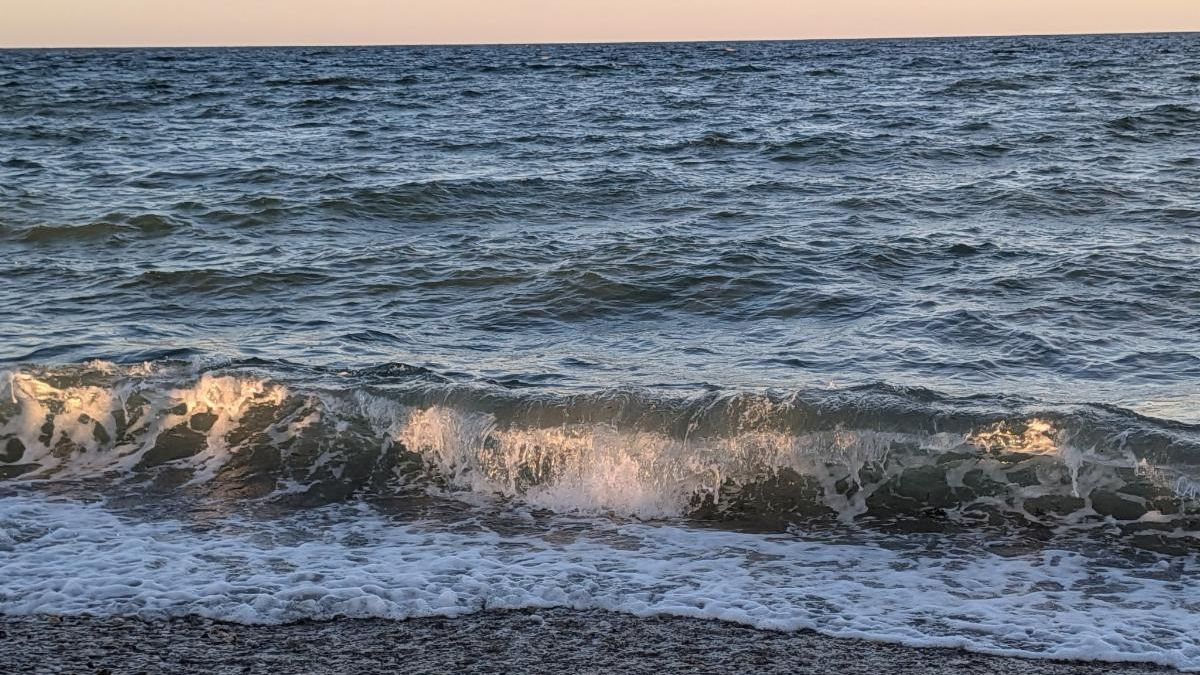 A wave breaking on State Beach at dusk