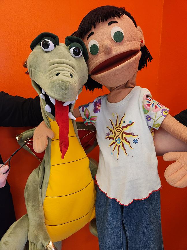 Our new Dragon puppet, Mrs Kitchen gets a hug from a puppet friend