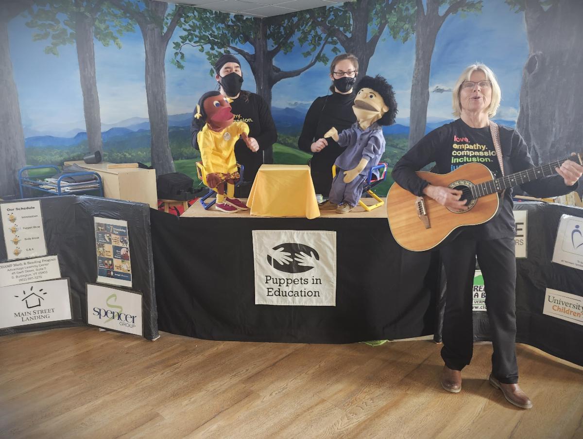 A puppet show with a person a playing guitar and singing