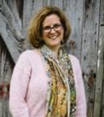 Headshot of Amy Wardwell who is smiling and wearing a pink sweater and colorful scarf