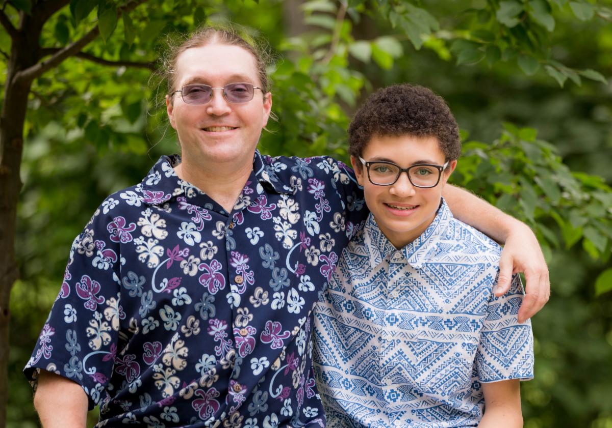 Parent with arm around their teenage child