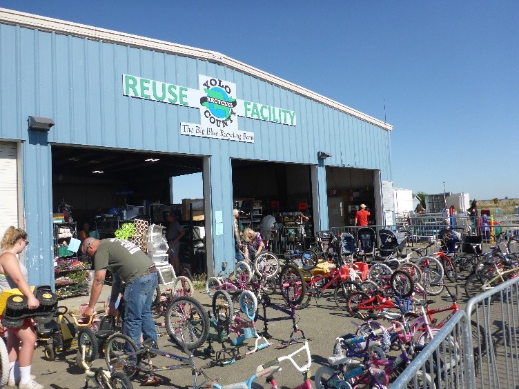 blue building saying yolo county reuse facility with many bikes out front and a couple of people