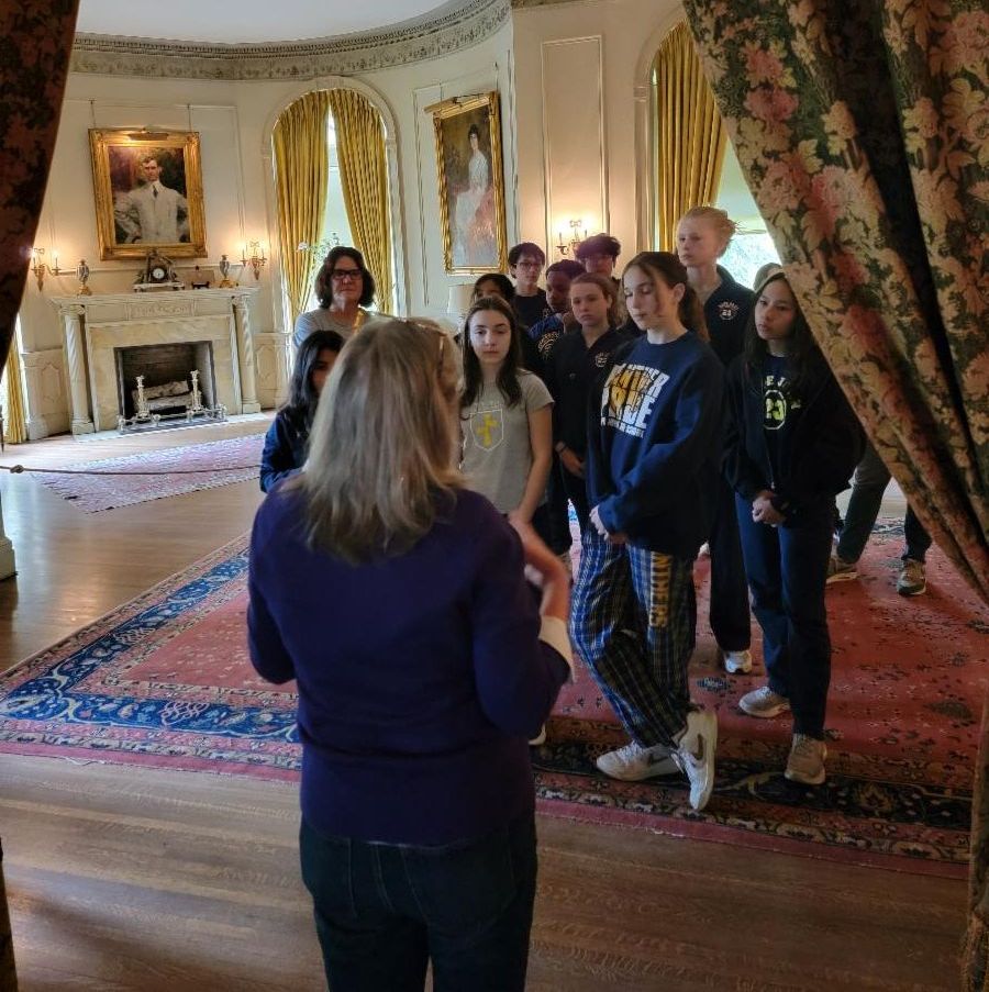 Color image of a tour guide giving a tour of the interior of the Dawes House