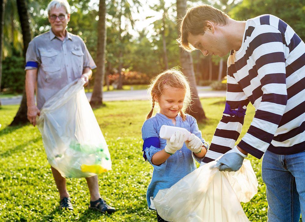 Image of man, woman and child picking up trash in Park