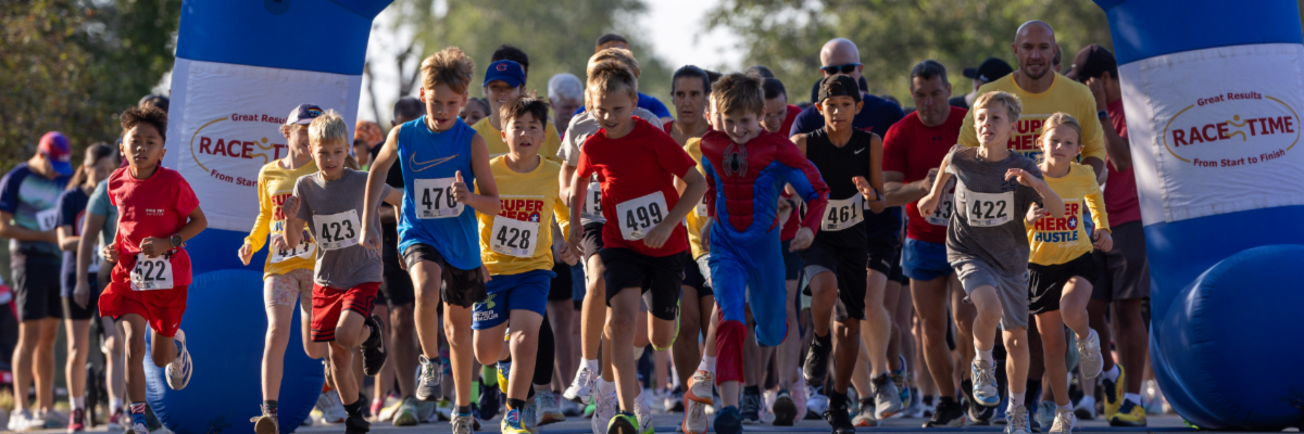 A big group of people running across a finish line.