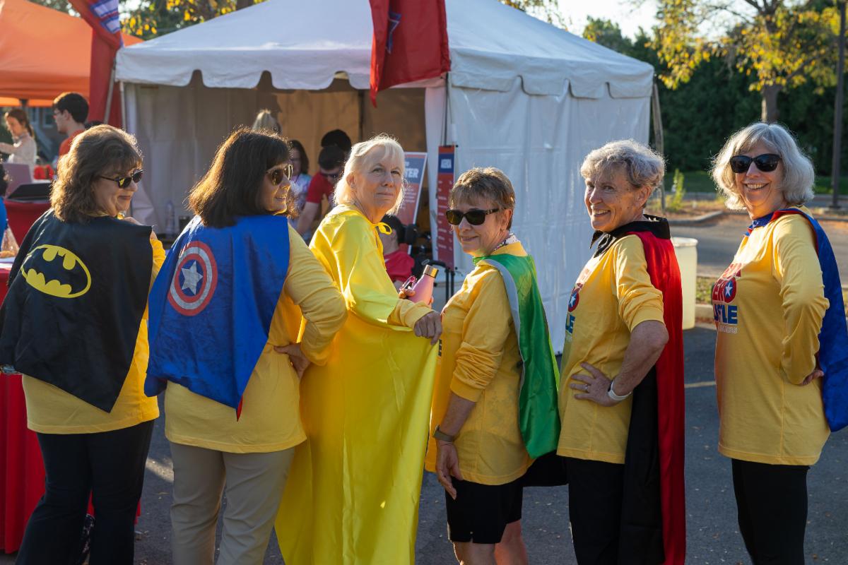 A group of women in an event setting with capes. 