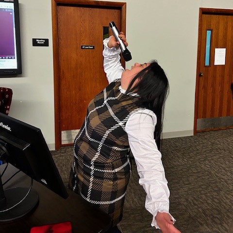 A young woman belts out a song as she sings karaoke.