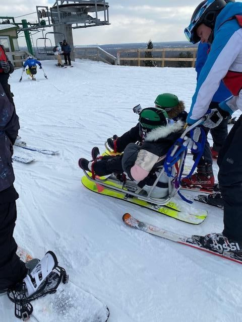 Two people prepared for adaptive skiing