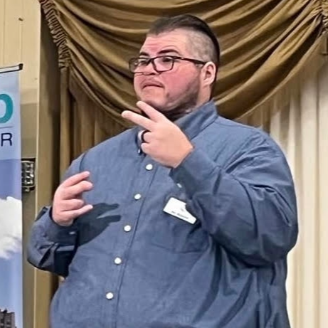 Jay Watson, Deaf Services Manager at Disability Network Eastern Michigan, is an American Sign Language interpreter at a Macomb  County Chamber of 
Commerce event.
