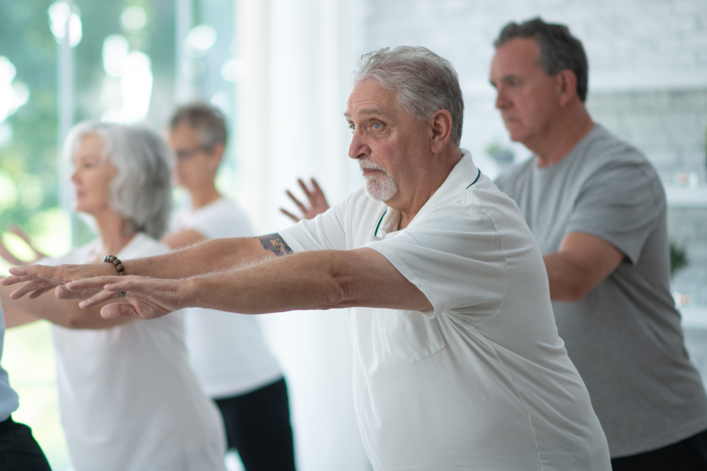 Group of adults doing tai chi indoors.