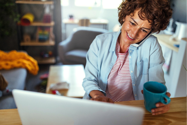 A woman at home is participating in a webinar on her laptop.