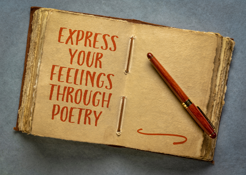 A pen lies on an open journal with "Express your feelings through poetry" written on a page.