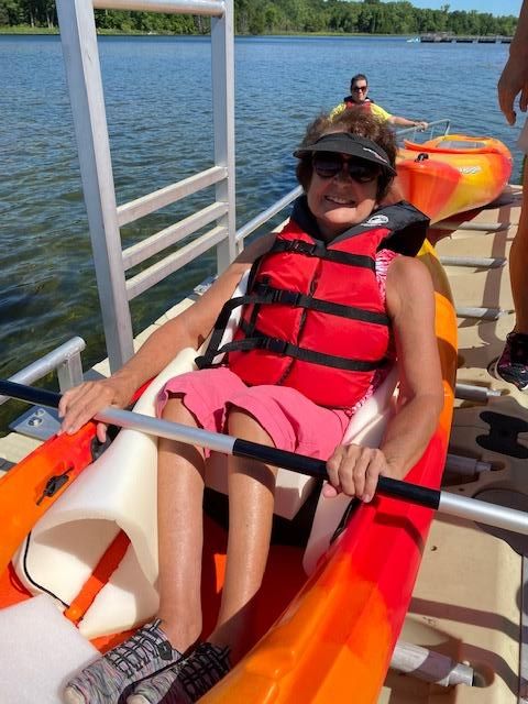 Woman in a kayak at an adaptive kayak launch.