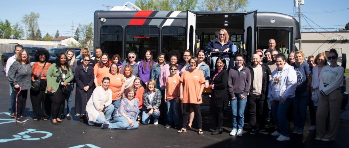 Group shot of Disability Network Eastern Michigan staff in front of a SMART paratransit bus.