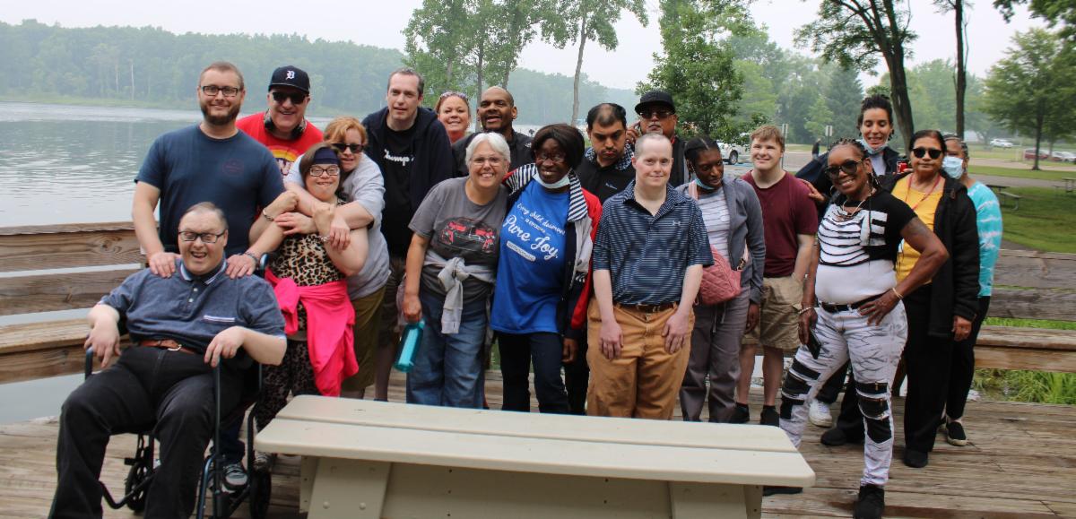 Diverse group of people with disabilities posing for a photo outside.